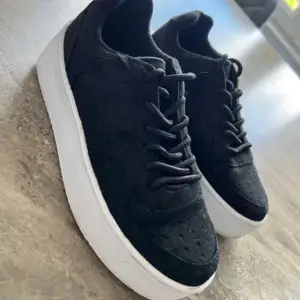 Snygga svarta sneakers från NLY i mocka med vit sula. Perfekta för vardagsbruk med en stilren design och bekväm passform. Skorna har snörning och en klassisk look som funkar till det mesta. Använd dem för en casual stil eller dressa upp med något mer formellt. Använd endast 1 gång 