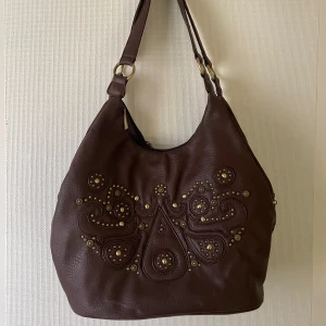 Brun väska  - Säljer denna bruna väska mer guldetaljer/nitar. Jättefint skick🤎🤎