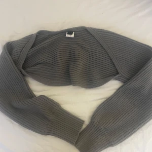 Grå ribbad bolero - Säljer en superfin grå ribbad bolero som aldrig är använd!