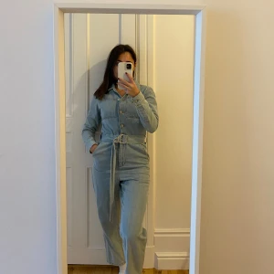 Denim byxdress NA-KD - En byxdress i denim ifrån NA-KD, väldigt fint skick då den är använd några gånger. Är i storlek 32 men upplevs större, jag är vanligtvis 34