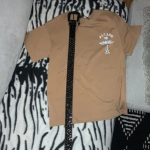 Bb Simon bälte - Säljer ett svart bälte med glittriga detaljer och silverfärgad spänne. Perfekt för att ge lite extra bling till din outfit. Bältet har flera hål för justerbar passform och passar både till vardags och fest. Det är i mycket bra skick och redo att användas direkt!