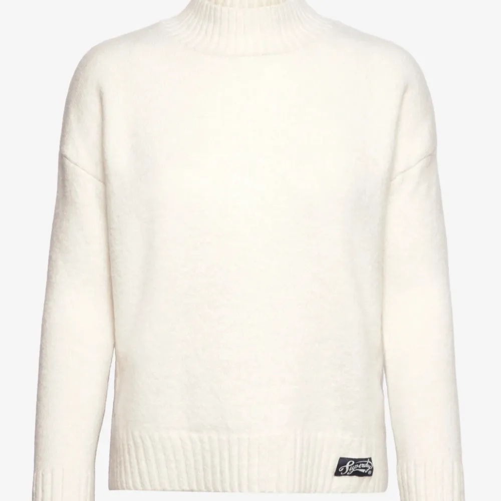 Säljer en snygg vit stickad tröja från Superdry i storlek M. Den har en hög krage och ribbade muddar vid ärmslut och nederkant. Perfekt för kyliga dagar och passar till allt! 🧶✨. Neuletakit & Villapaidat.