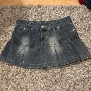 Jeanskjol från TRF - Säljer en snygg jeanskjol från TRF i en cool tvättad blå färg. Kjolen har en kort modell med veckade detaljer som ger en fin volym. Står att det är en stl 40 men skulle mer säga att de passar en stl 36/38
