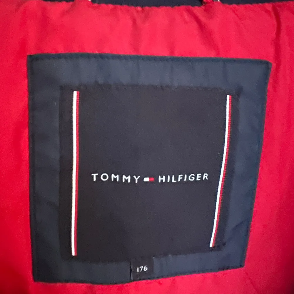 Säljer en snygg blå dunjacka från Tommy Hilfiger i storlek 176. Jackan har en cool röd insida och en praktisk huva. Perfekt för kalla vinterdagar med sin varma och puffiga design. Den har en dragkedja framtill och är i mycket bra skick. Passar både till vardags och lite finare tillfällen.. Jackor.