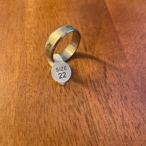 Silverfärgad ring med stjärnmönster - Snygg och stilren ring i silverfärg med ett subtilt stjärnmönster runtom. Perfekt för både vardag och fest. Storlek 22, passar de flesta fingrar. Enkelt att matcha med andra smycken för en komplett look.