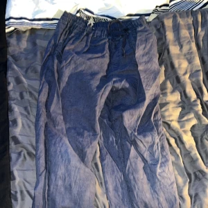 Blå linnebyxor från Pomp de Lux - Säljer ett par blå byxor från Pomp de Lux i storlek 158/164. De har en elastisk midja med snörning för extra komfort. Perfekta för en avslappnad stil och passar bra till både vardag och skola. Byxorna är i bra skick och redo för en ny ägare!