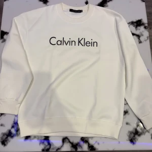 Calvin Klein tröja - Pris kan sänkas. Säljer en tröja från Calvin Klein i storlek M. Passar även för dom som bär S. Tröjan har en design med Calvin Klein-loggan tryckt på framsidan. Den är långärmad och gjord i ett mjukt material som är perfekt för både vardag och avslappnade tillfällen. Passar perfekt till jeans eller joggers. 