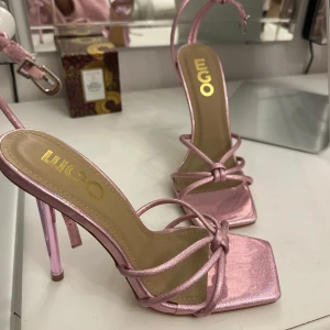 Rosa glittriga klackskor från Ego - Säljer ett par supertrendiga rosa klackskor från Ego. De har en glittrig finish och smala remmar som knyts runt foten. Helt oanvända! 💖