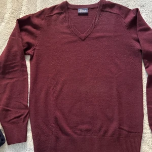Vinröd ulltröja från Peak Performance - Säljer en snygg vinröd tröja från Peak Performance i 100% lammull. Den har en stilren v-ringning och är perfekt för både höst och vinter. Tröjan är i mycket bra skick och passar perfekt för en casual look eller lite mer uppklädda tillfällen. Supermysig och varm!