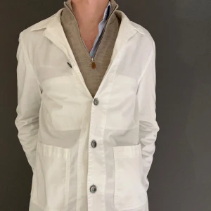 Vit overshirt från Oscar Jacobson - Säljer en stilren vit overshirt från Oscar Jacobson. Den har en klassisk design med knappar framtill och två fickor. Perfekt för både formella och avslappnade tillfällen. Overshirten är i mycket bra skick och passar perfekt till alla årstider.Tveka inte på att höra av dig vid ytterligare frågor samt fler/bättre bilder!☺️ 