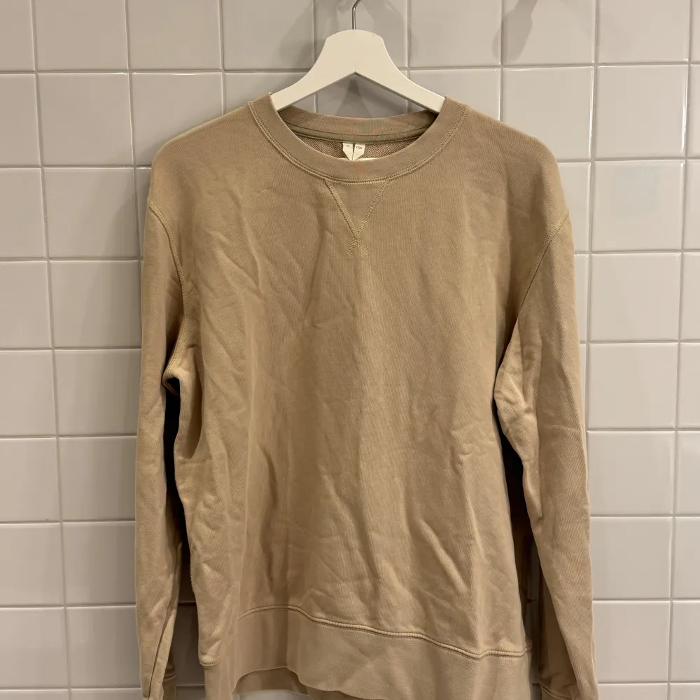 Klassisk beige sweatshirt från Arket i storlek Medium. Mjuk och bekväm med tidlös design, perfekt för både vardag och avslappnade stunder.. Tröjor & Koftor.