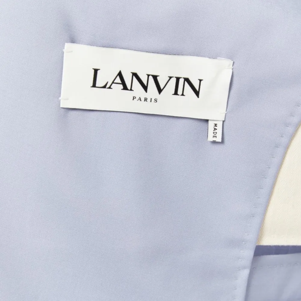 Säljer en elegant ljusblå kavaj från Lanvin i mycket bra skick. Den har en dubbelknäppt design med sex mörka knappar och två fickor framtill. Perfekt för vår och sommarens fester eller baler. Passar dig som gillar en stilren och klassisk look. Aldrig använd. Nypris 27700. Storlek s.. Kostymer.