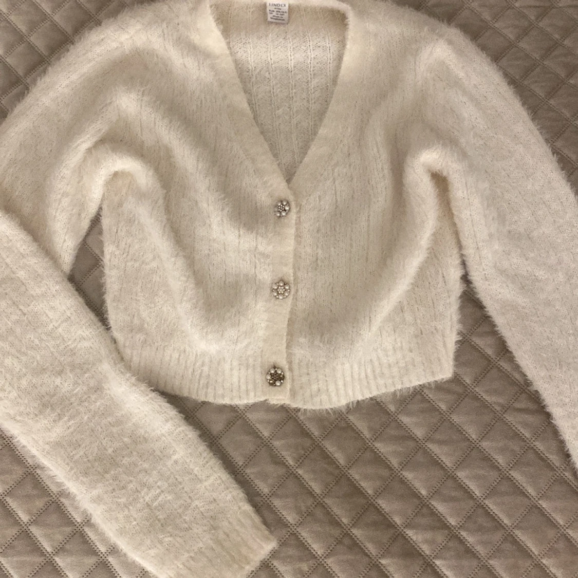 Vit fluffig kofta med pärlknappar