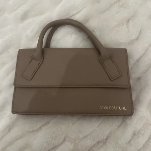 Beige handväska från Viva Couture - Säljer en stilren beige handväska från Viva Couture. Väskan har en elegant design med två handtag och en praktisk dragkedja inuti. Perfekt för både vardag och fest! 👜✨