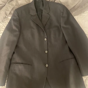 Mörkgrå kavaj - Hjälper pappa sälja sin mörkgråa kavaj, lappen är borta så vet inte stl. men skulle säga M-L. I toppenskick, sparsamt använd. Vid snabb affär kan priset diskuteras