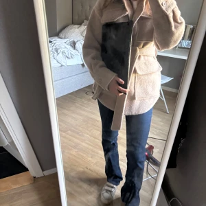 Beige kappa med bälte - Säljer en stilren beige kappa med bälte i midjan. Jackan har långa ärmar och stora fickor framtill. Den är aldrig använd så är helt ny. Perfekt för vår, sommar och höst. Jackan är i storlek xs men passar även i s och m. Hör av för fler frågor 💕