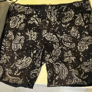 Mönstrade shorts från Polo Ralph Lauren - Snygga shorts från Polo Ralph Lauren med ett unikt paisleymönster i svart och vitt. Shortsen har en rak passform och knäppning fram.