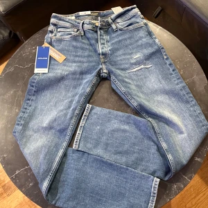 Blå jeans från Jack & Jones - Helt nya snygga blå jeans från Jack & Jones med en slim passform. De har en klassisk femficksdesign och är tillverkade i slitstarkt denim. Perfekta för en stilren look. För fler bilder är det bara och skriva!
