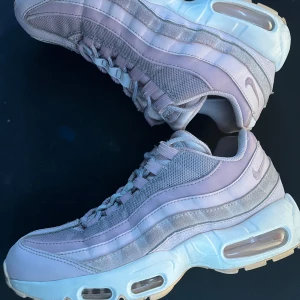 Nike Air Max 95 i ljuslila och grå - Säljer ett par Nike Air Max 95 i en snygg kombination av ljuslila och grå. Skorna har den klassiska Air Max-dämpningen och en stilren design med snörning. Perfekta för både stil och komfort.