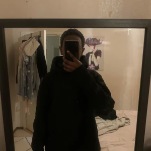 Svart hoodie - Säljer en stilren svart hoodie med långa ärmar och en klassisk huva. Perfekt för en avslappnad look. Passar bra till både jeans och träningsbyxor.