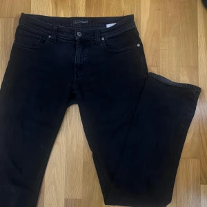 Svarta jeans från Denimbirds  - Snygga svarta jeans från denimbirds. De har en tight passform upptill och lite lösare där nere så de går över skon. Midjemått 76 cm. 