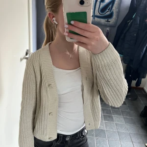 Beige stickad kofta - Säljer en mysig beige-vit stickad kofta med knappar framtill. Är i storlek 146-152 men passar även xs. Endast använd två gånger. Tveka inte att höra av dig om du har några frågor!