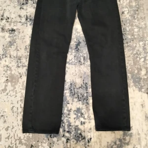 Svarta jeansbyxor - Snygga svarta jeansbyxor med en klassisk straight passform. Perfekta för en stilren look. De har en enkel design utan extra detaljer, vilket gör dem lätta att matcha med olika outfits.