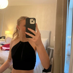 Svart halterneck topp - Snygg svart halterneck topp med öppen rygg i storlek 34 från Nelly