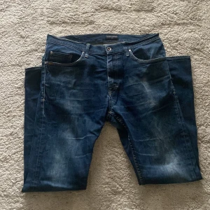 Mörkblå jeansbyxor tiger of Sweden jeans 31/32 - Snygga mörkblå jeans med en klassisk femficksdesign och subtila slitningar för en trendig look. Perfekta för en avslappnad stil. Har dock ett hål ett litet hål i skrevet som man inte ser. Bara att hojta till vid funderingar eller fler bilder! Kan även stryka jeansen vid köp.