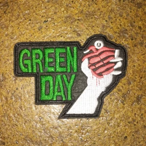 Green Day patch/tygmärke - Ett snyggt tygmärke med Green Day (American Idiot). Köpt rätt billigt samt använd därav priset. Säljer då den inte får plats på min battlevest längre, tyvärr. Skickas endast via Instabox!! Använd så smått sliten men inte dåligt skick, även två små fläckar på loggan som knappt syns när man har den påsydd! Mått: 11,5 x 8,3. 