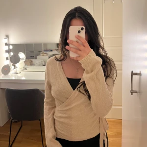 Rosa omlottkofta från Bik Bok - Säljer en mysig rosa omlottkofta från Bik Bok. Koftan har långa ärmar och knytband i midjan för en justerbar passform. Perfekt för lager-på-lager under kyligare dagar. Passar både till jeans och kjol.