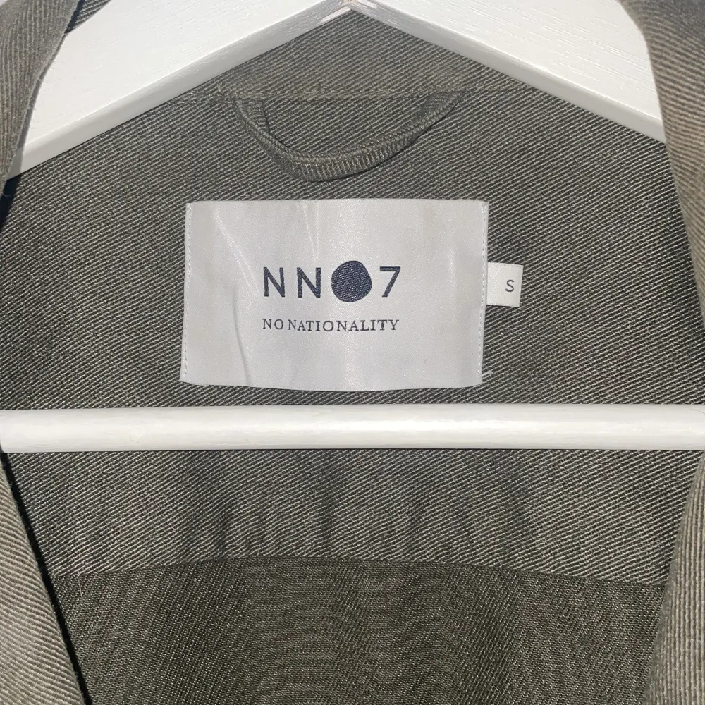 Snygg grön overshirt från NN07 med knappar framtill och två bröstfickor. Perfekt för lager-på-lager-stil. Den har en klassisk krage och långa ärmar, vilket gör den idealisk för både vår och höst. Nyskick från märket nn07 storlek S kan gå ner i pris vid snabb affär skriv vid minsta fråga eller fundering!. Takit.