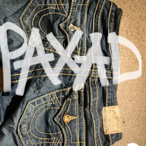 Paxade!! Blå bootcut jeans från True Religion - Snygga blå utsvängda jeans från True Religion med coola detaljer på bakfickorna. Mått får ni p sida 4❤️