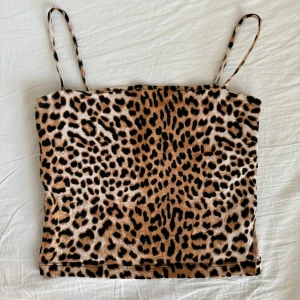 Leopardmönstrat linne  - Snyggt leopardmönstrat linne med smala axelband från Gina Tricot. Perfekt till vardags eller en utekväll. Har bara använts ett fåtal gånger och har inga defekter. Den är lite kortare i modellen och har dubbelt tyg över bysten så man slipper bära bh! 🤎