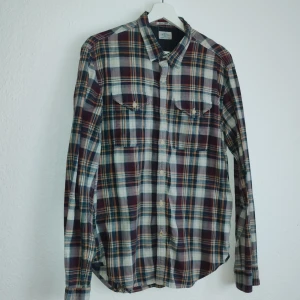 Rutig skjorta från Replay - Säljer en snygg rutig skjorta från Replay i flera färger som vinröd, blå och beige. Skjortan har långa ärmar och knappar framtill samt två bröstfickor. Perfekt för en avslappnad stil med en touch av klassisk design.