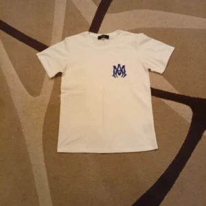 T-shirt med blått tryck - En vit T-shirt med blått tryck pris kan sänkas vid snabb affär!
