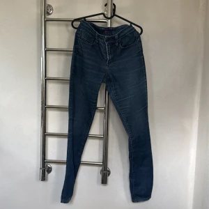 Blå jeansbyxor - Snygga blå jeansbyxor med en tight passform. De har klassiska fem fickor och en dragkedja framtill. Perfekta för en stilren look.