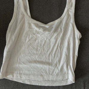 Vit ribbad linnetopp - Säljer en vit ribbad linnetopp med breda axelband. 