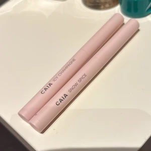 Ögonskuggspennor från CAIA - Två ögonskuggspennor från CAIA i nyanserna Icy Champagne och Snow Spice. Pennorna har en krämig konsistens och kommer i en stilren ljusrosa förpackning. Perfekta för att skapa en glittrande och elegant look. Från julkalendern 2024. Säljer båda för 250kr eller 150kr/st. Endast provade. 