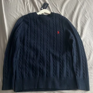 Mörkblå stickad tröja från Polo Ralph Lauren - Säljer en mörkblå stickad tröja från Ralph Lauren som är helt oanvänd och helt ny