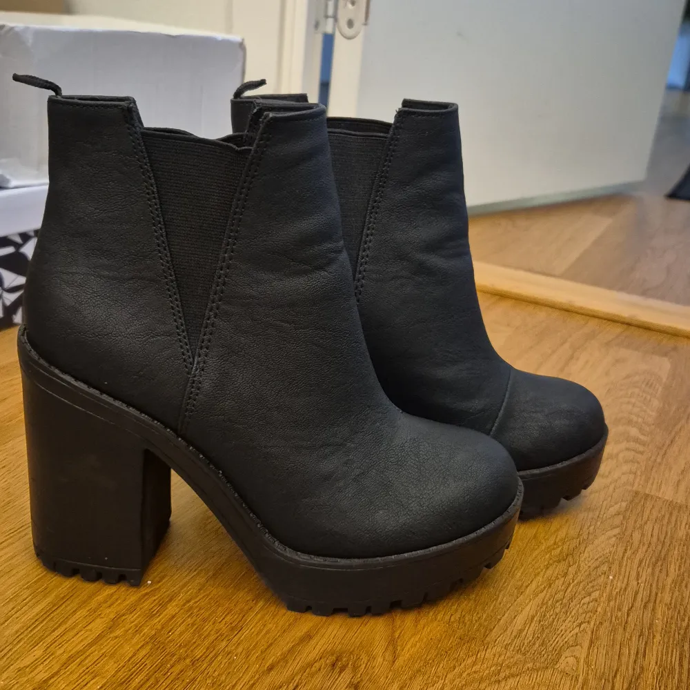 Snygga svarta boots med hög klack och rund tå. De har en elastisk panel på sidan för enkel på- och avtagning. Perfekta för att ge lite extra höjd och stil till din outfit.. Kengät.
