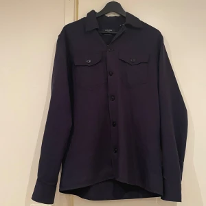Mörkblå overshirt från Jack & Jones - Säljer en mörkblå overshirt i storlek S men passar absolut M. Den är i ett fint skick och har inte några tecken på användning. Denna overshirt tillverkas inte längre och är köpt för 700, jag säljer denna för 350. Vid frågor och funderingar är det bara att höra av sig!