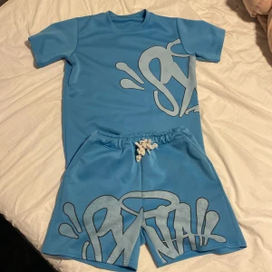 Blå t-shirt med graffiti-mönster -  blåt syna world set med inga större defekter och bra skick, storlek S