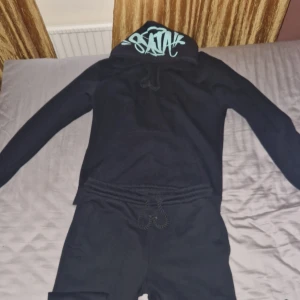 Syna World Tracksuit - Säljer denna mycket fräscha Syna World tracksuiten på grund av fel storlek. Den har endast används en gång och har absolut inga defekter, den är i helt nytt skick.   Storleken är i XXL men passar du som är XL briljant. Den sitter lite slimmad vid vaderna men modellen är till för saggin.   Skriv vid intresse!