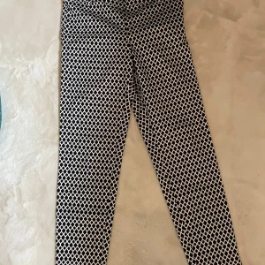 Svartvita mönstrade byxor från H&M - Snygga svartvita byxor från H&M med ett unikt geometriskt mönster. 🖤🤍 Byxorna har en tight passform och är perfekta för att ge din outfit en trendig touch. Bomull 100%. Använda 2 gånger.