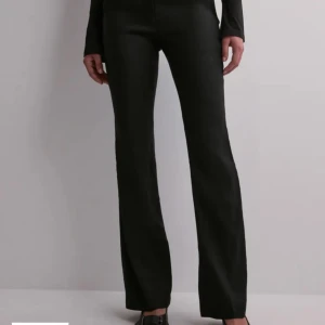 Svarta linnebyxor med bootcut - Snygga svarta linnebyxor med bootcut-stil och låg midja. Perfekta för en stilren look. De ser ut som kostymbyxor fast är av linnetyg! 