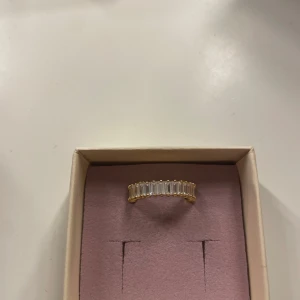 Guldfärgad ring med kristaller - Elegante guldfärgad ring prydd med rektangulära kristaller som ger en lyxig känsla. Säljer då den är för liten i storleken..🌺🩷 Storlek 17
