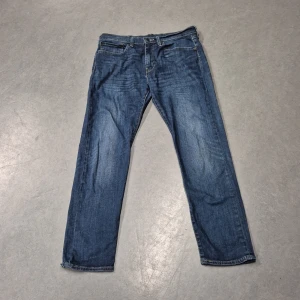 Levis 502 jeans - Snygga Levis 502 jeans i en klassisk blå färg. De har en straight passform och är tillverkade i slitstarkt denim. Perfekta för en avslappnad stil med fem fickor och en dragkedja.