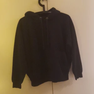 Svart hoodie från Bik Bok - Säljer en svart hoodie från Bik Bok i storlek S. Den har en klassisk design med huva och dragsko samt långa ärmar. Perfekt för en avslappnad stil.