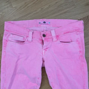 Lågmidjade Rosa Jeans - Ljusrosa lågmidjade jeans som tyvärr var försmå för mig, lite bootcut men mer raka i formen. Ej skinnyjeans. Midjemått: 80cm  Resterande mått finns på bild.